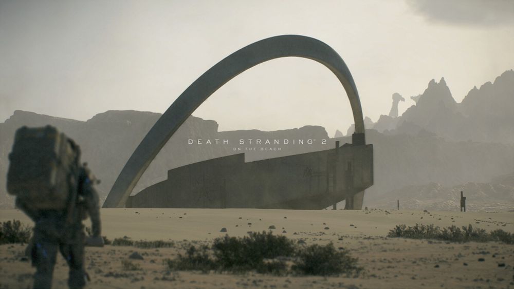 Screenshot from the video game Death Stranding 2. A large structure with an arch is seen in the far distance. A man, in the foreground, is seen walking towards it.