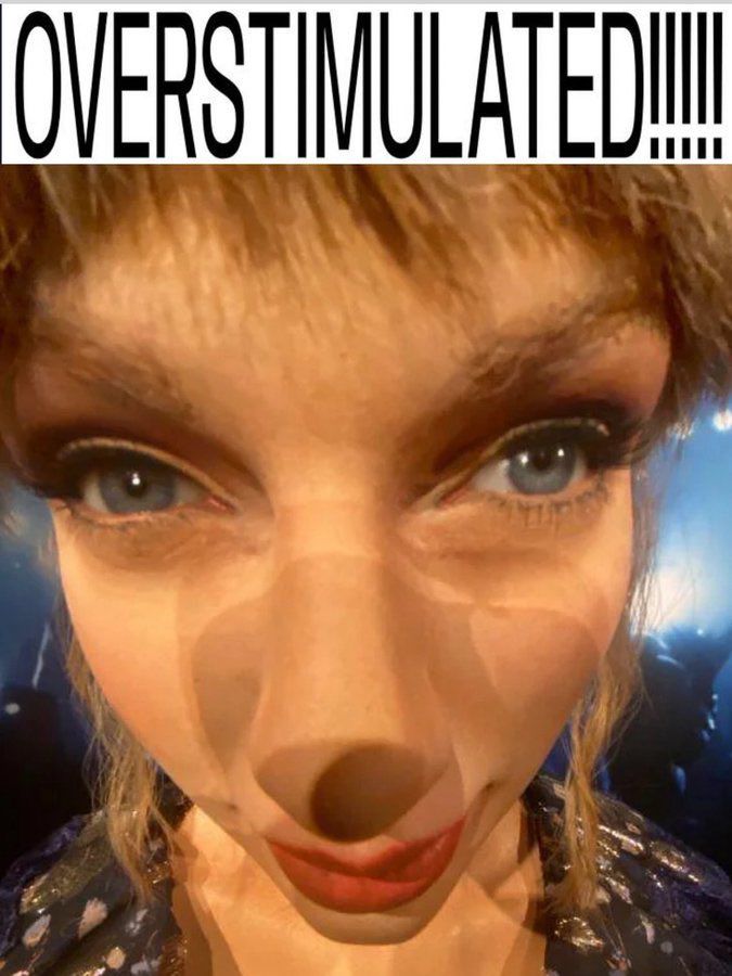 picture of wax figure Taylor’s face at a weird angle with text above it saying overstimulated 