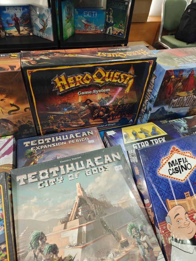 A photo of a bunch of board games with the game HeroQuest in the middle. 