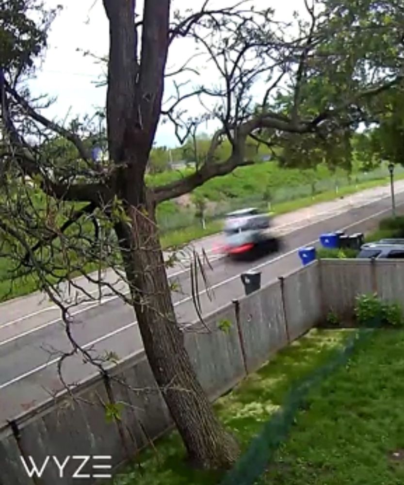Screenshot from a neighbor’s security camera capturing two cars drag racing down St Anthony Ave near Herschel in 2020. The white car is in the separated bike lane.