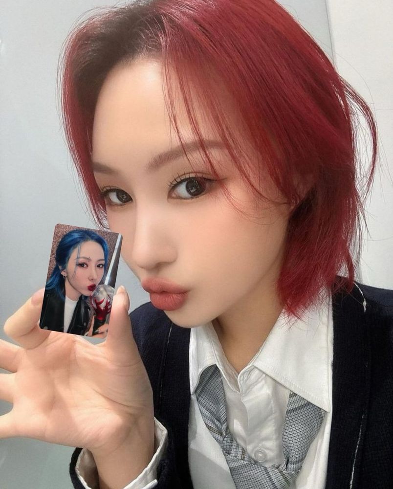 Siyeon from Dreamcatcher holding a photo of Yoohyeon from dreamcatcher 