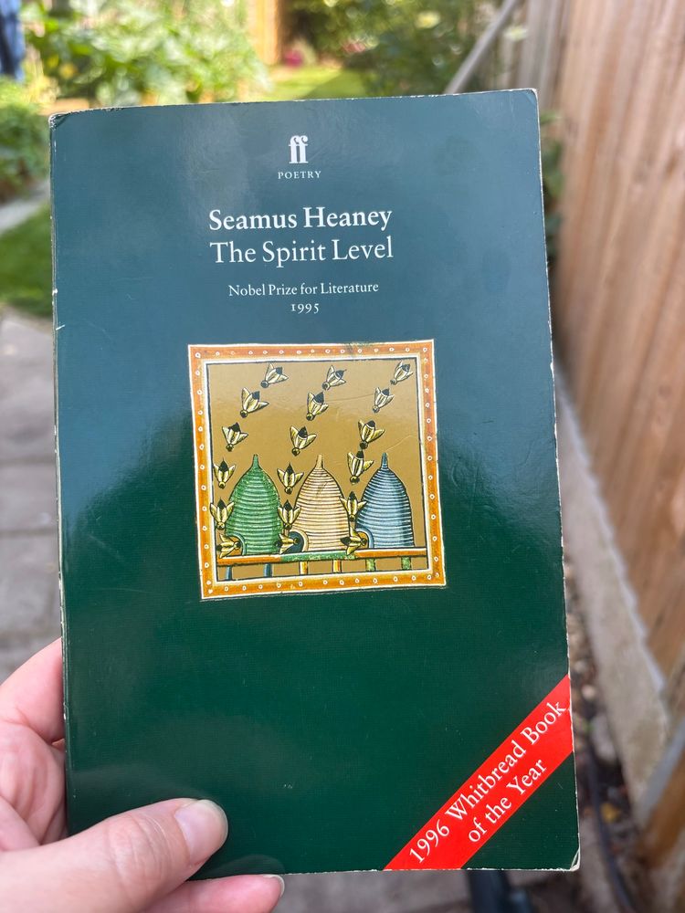 A hand holds the book The Spirit Level by Seamus Heaney