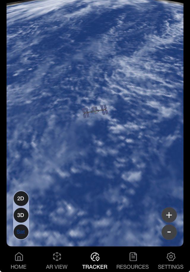 A screenshot from the Spot The Station app representing e ISS over a blue ocean swirled with white clouds.  