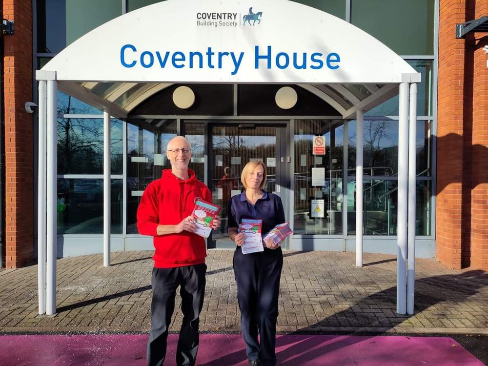 Scott and Jacqui standing outside Coventry House holding treecycling leaflets