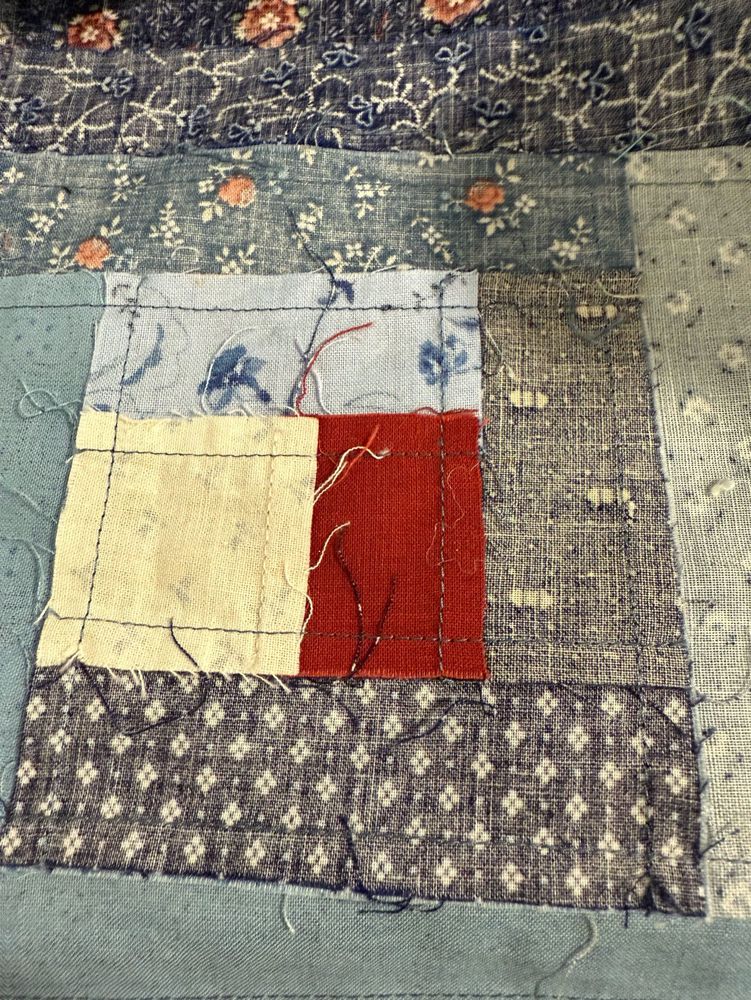 Backside of log cabin quilt block. Many tidy machine stitches can be seen