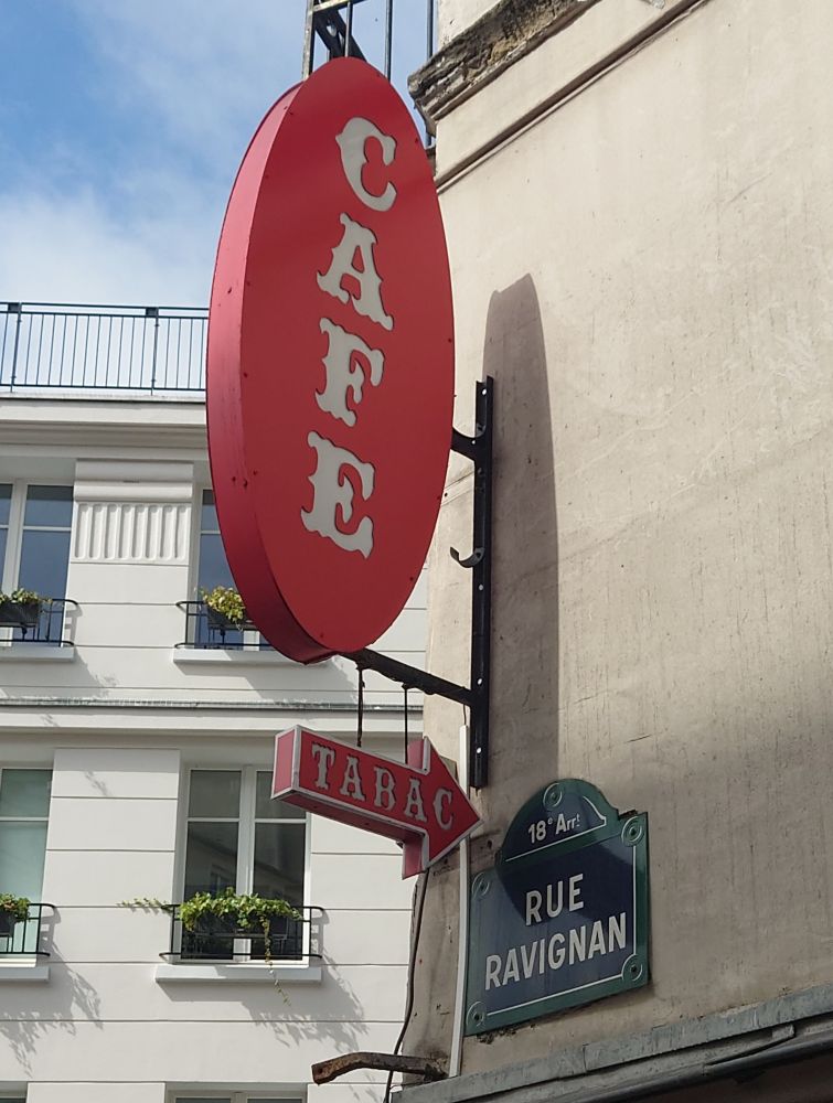 Photo taken at Café Tabac/ Cafe Genovese in Paris of the cafe and tabac sign and the street sign Rue Ravignan