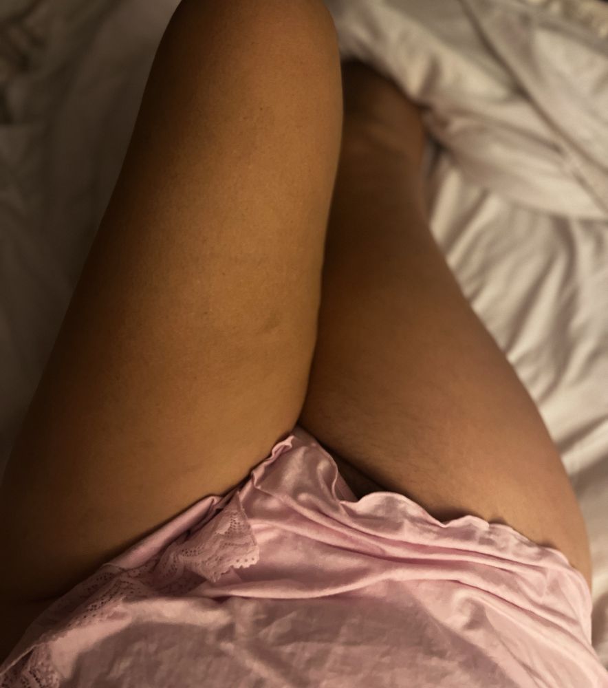 PL and her legs, artfully arranged on a bed with a pink nightie