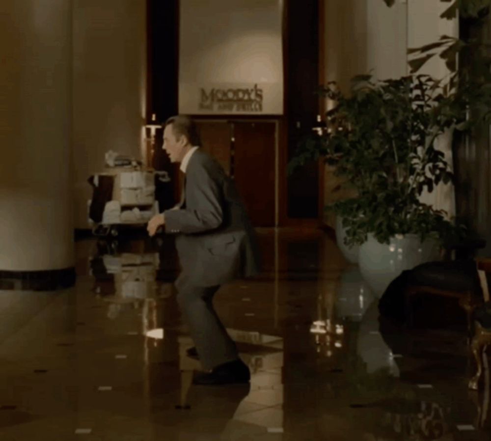 a man is dancing in front of a moody 's sign