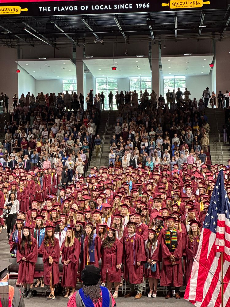 View of people in a auditorium in graduation regalia 