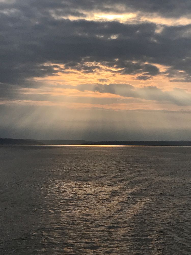 sunset over inland saltwater bay. rays of light filtered thru clouds