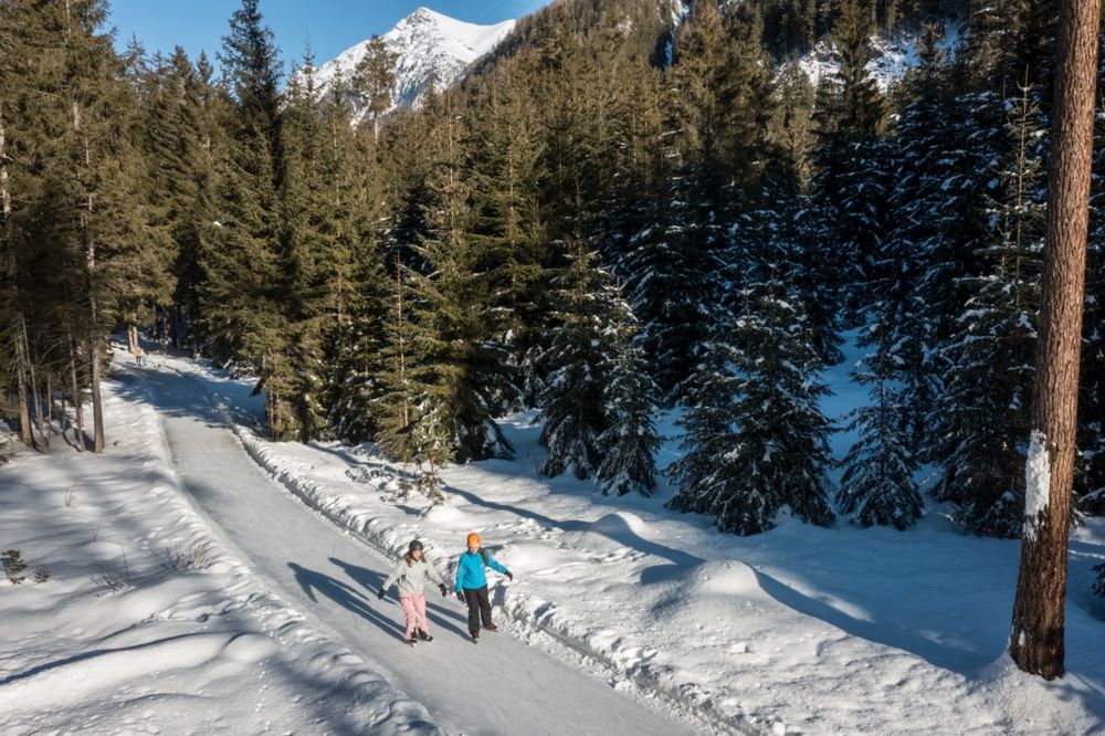 Eisweg Engadin, zwei Personen laufen auf Schlittschuhen durch den Wald. (Bild: Schweiz Tourismus / Florian Frey)