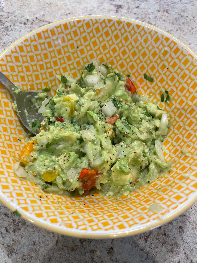 Behold the guac in a a bowl, fresh and green 