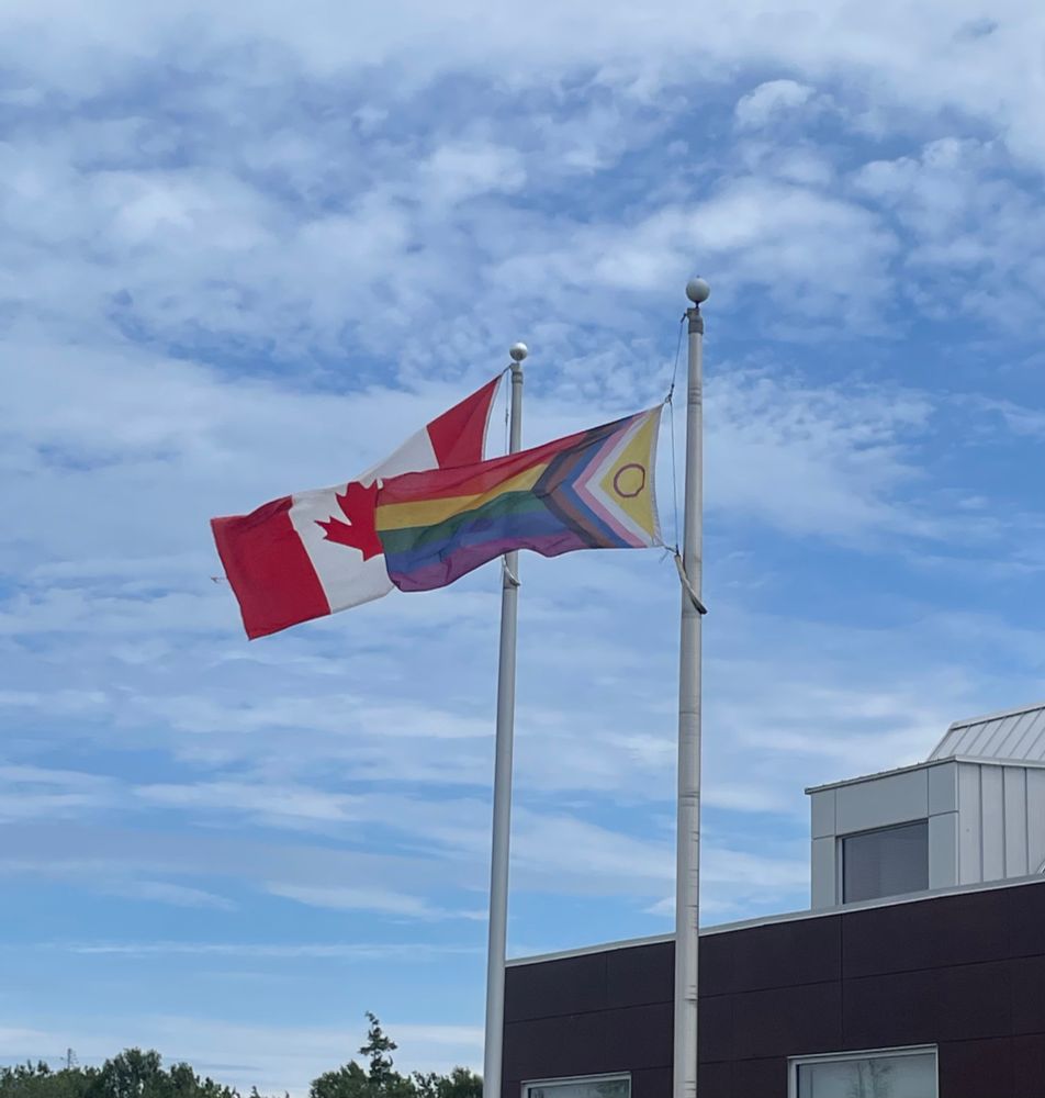 At a Canadian Heritage Site, the Canadian flag flies next to an 2SLGBTQI+ flag. 