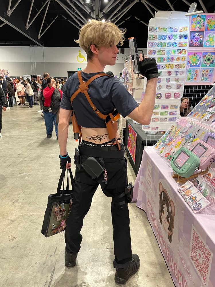 A dude dressed as Leon Kennedy from Resident Evil 4, but he’s wearing a crop top and has a fake tramp stamp tattoo.