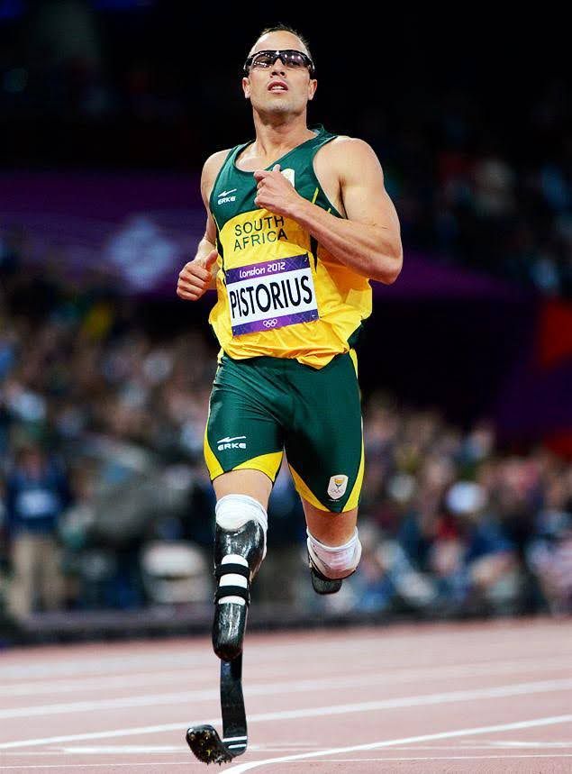 Male athlete runner runs at paralympics with both prosthetic (special for running, curved form) legs. View from the front, only one prosthetic leg is seen