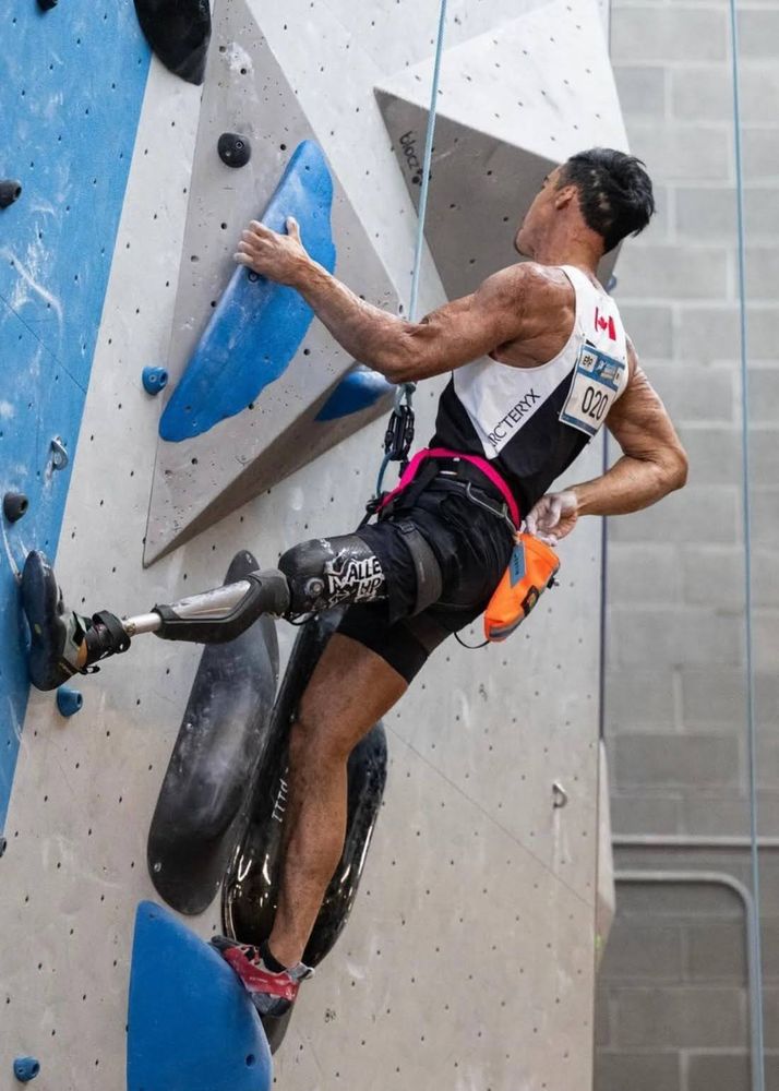Male athlete climber with one prosthetic leg, view from side and his back