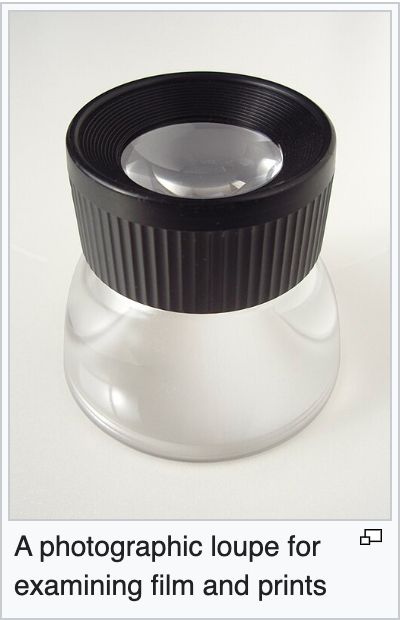 the glass object is a loupe, pictured is the wikipedia description: "A photographic loupe for examining film and prints."