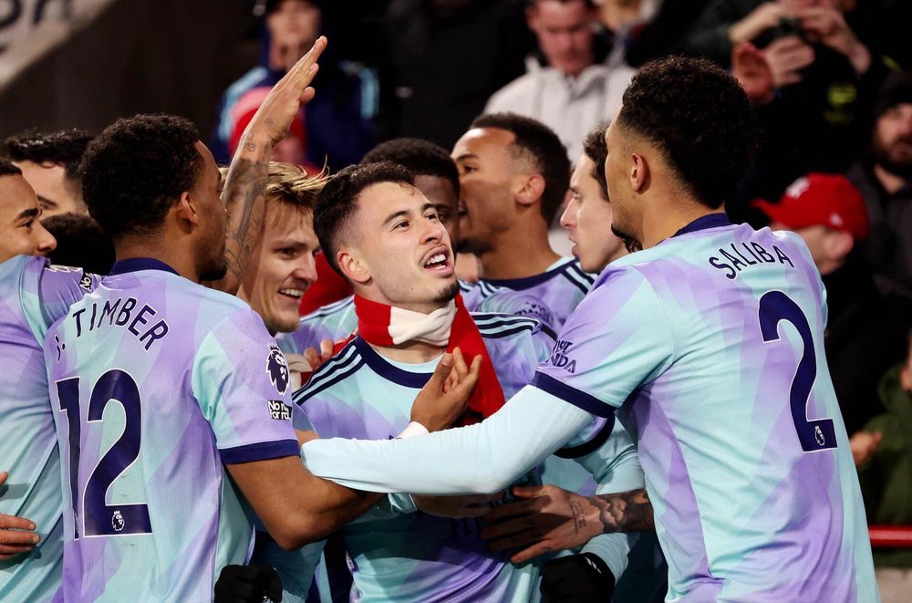 A picture of Martinelli, whom Seb and Jake love, celebrating after his goal vs Brentford. Players are surrounding in adoration, and he has an Arsenal scarf around his neck 