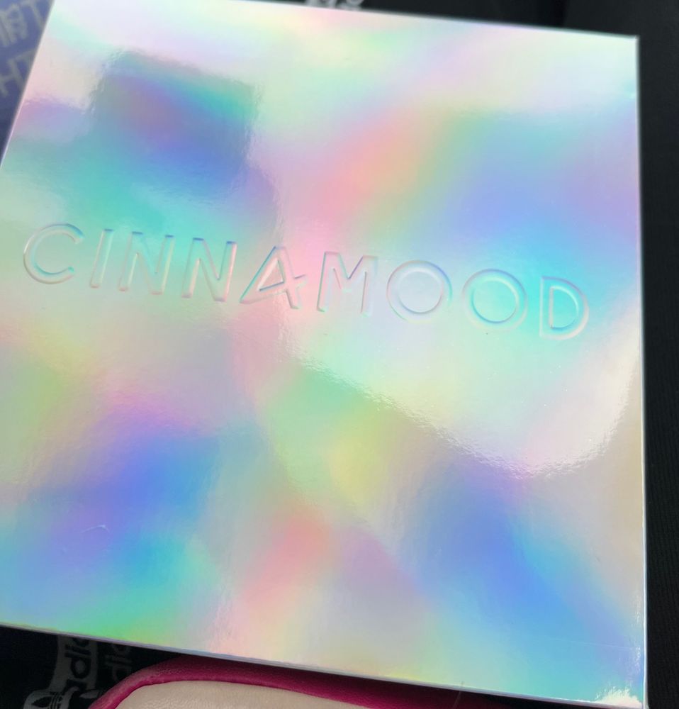 Eine holographische Schachtel aus Pappe mit einer Prägung „CINNAMOOD“