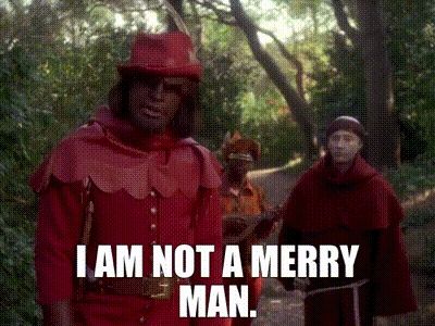 Star Trek: The Next Generation's Geordi, Data, and Worf are dressed in Robin Hood attire, standing out in the woods. Worf says, "I am *not* a merry man!"