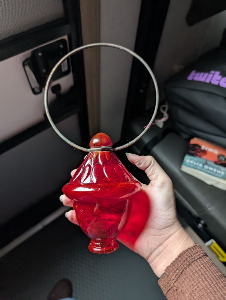 A red glass piece with an iron hoop attached. 