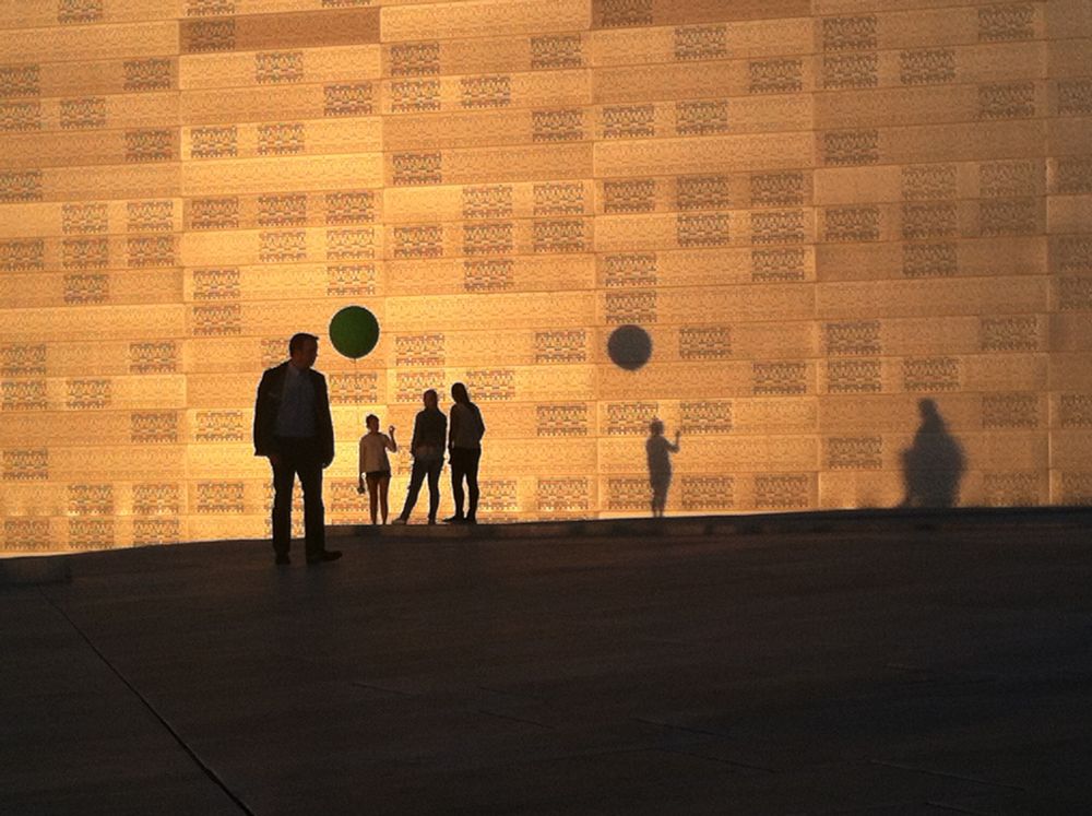 People and their shadows on the Oslo opera house roof at sunset in June 2014
