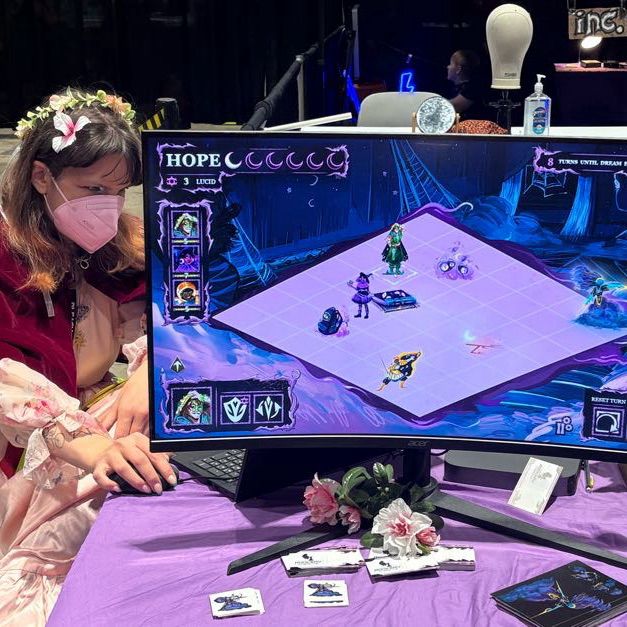 Pictures of con-goers playing A Good Nights Rest at C2E2! This screen shows an RPG-like grid of characters battling