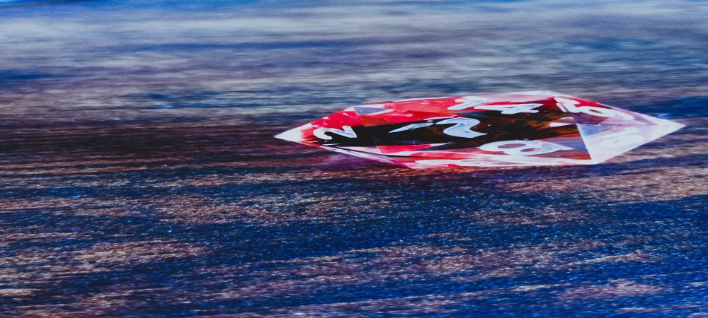 A beautiful D20 die with a heron logo in place of the number 20