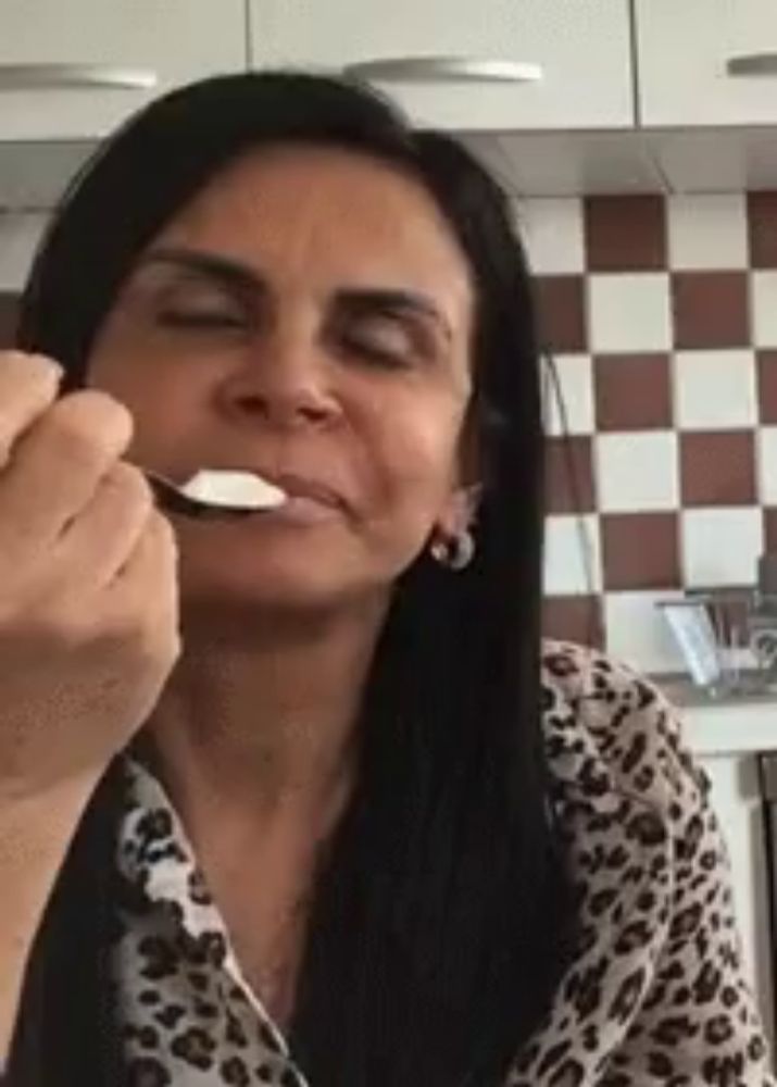 a woman is eating yogurt with a spoon .