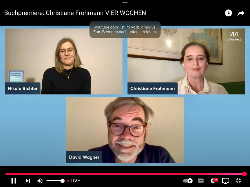 Screenshot aus dem livestream zur Premiere von Christiane Frohmanns ‚Vier Wochen‘ mit David Wagner mit weißem Vollbart und schwarzem Oberteil. 