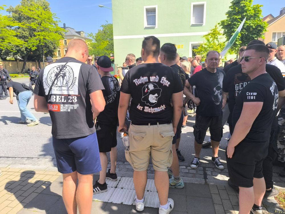 Ein Teilnehmer trägt ein T-Shirt mit der Aufschrift "Ruhm und Ehre der Wehrmacht". Darunter ist die Abbildung eines Wehrmachtssoldaten