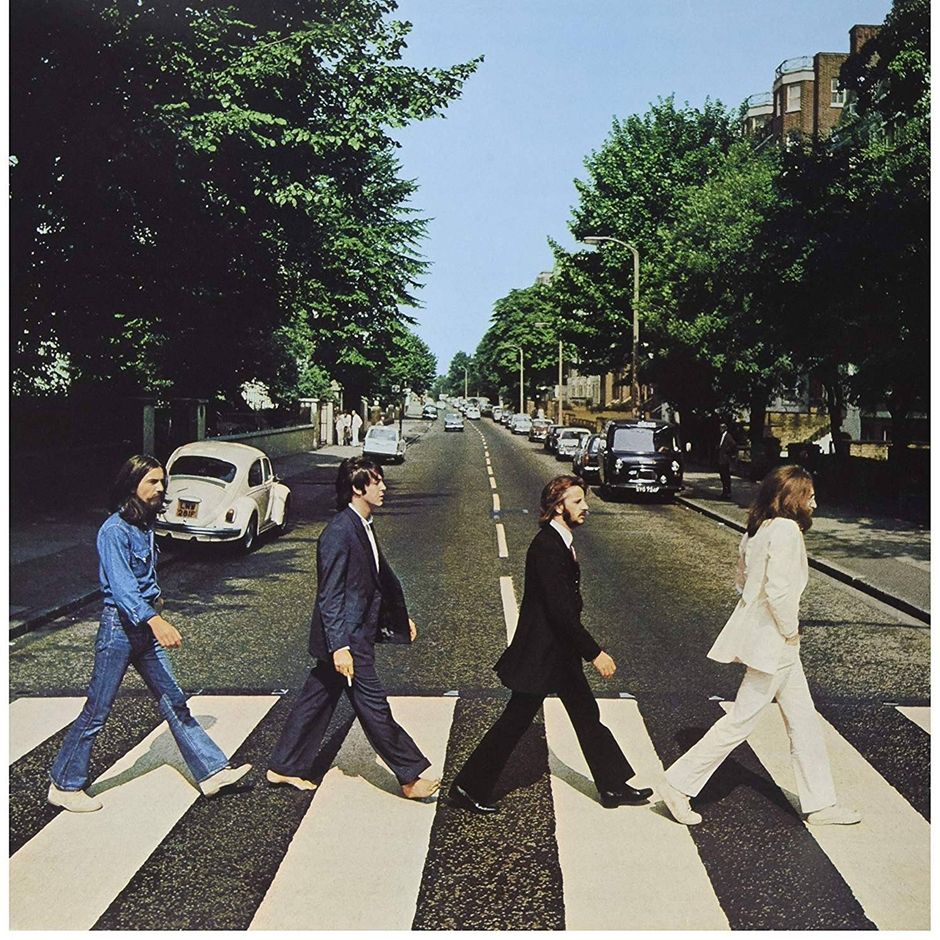 The Beatles walking across the zebra crossing on the cover of Abbey Road: George in double denim, Paul barefoot, Ringo in black, John in white