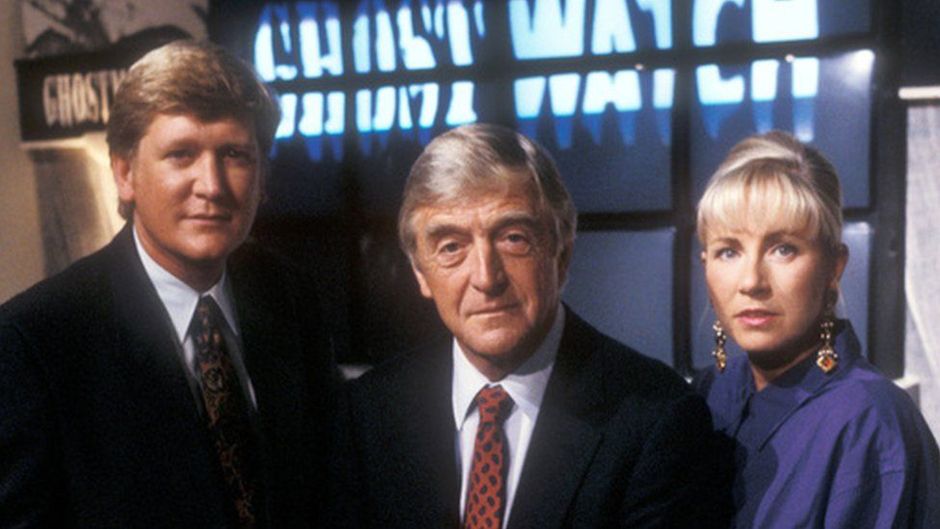 Mike Smith, Michael Parkinson and Sarah Greene look to camera in front of a bank of TV screens spelling out the word GHOSTWATCH