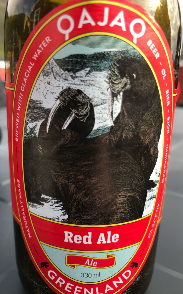 Greenlandic beer label, a red oval label ‘Qajaq Red Ale Greenland’ with a picture of a pair of walrus. 
