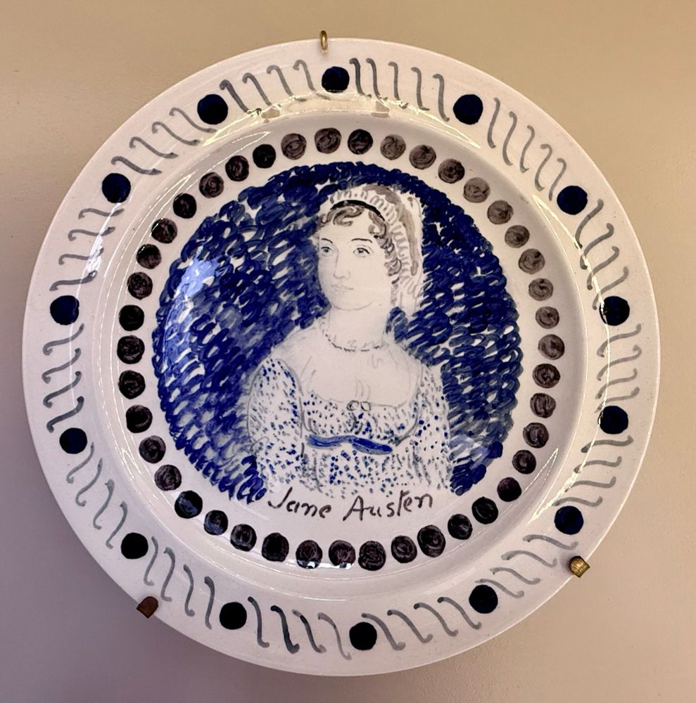 Blue painted white ceramic plate with a portrait of Jane Austen.