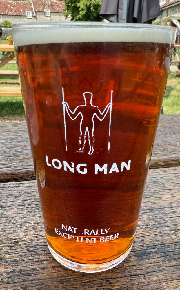 Photograph of beer in a pint glass labelled ‘Long Man’ from the Long Man Brewery and with the image of the Chalk figure of the Long Man of Wilmington.