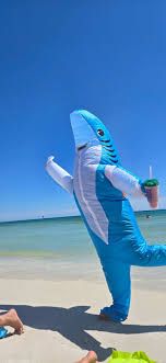 Someone in a shark costume with an iced coffee