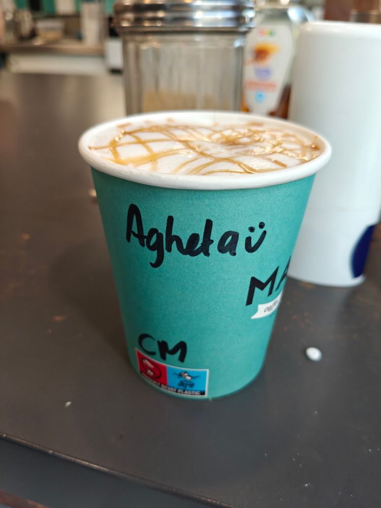 Cup of coffee saying "Agheta" which is not the appropriate spelling of Agatha. There is also a smiley which can be interpreted as an ü so this adds to the confusion.