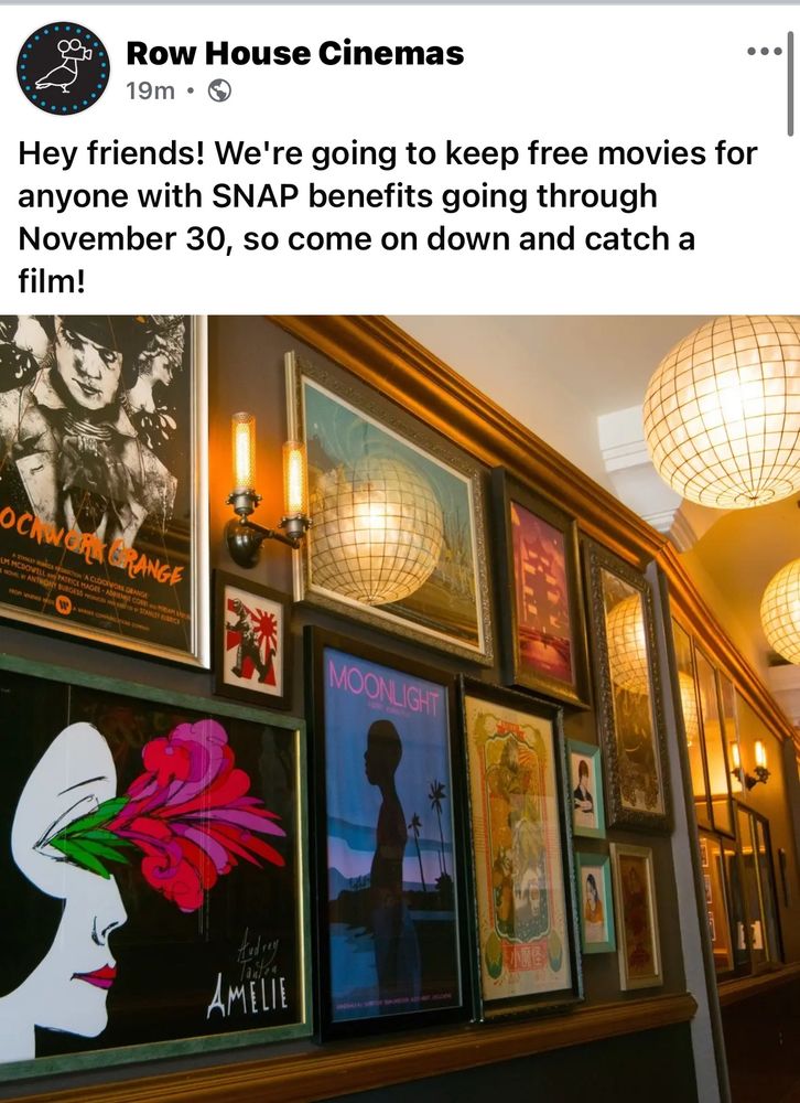 a wall of movie posters on a wall with candle sconces and a ceiling with glass glove lights. 
the announcement reads: 
Row House Cinemas
19m •
Hey friends! We're going to keep free movies for anyone with SNAP benefits going through November 30, so come on down and catch a film!