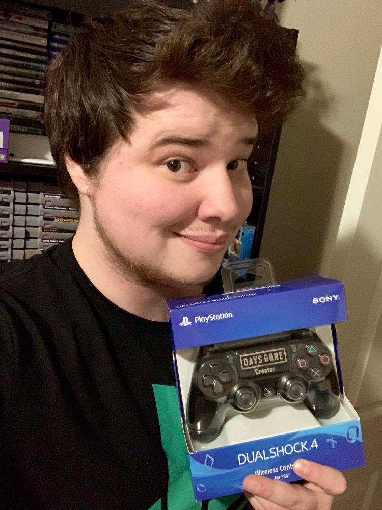 Sam Potter holding a Days Gone creator dualshock 4 on the launch day of Days gone.