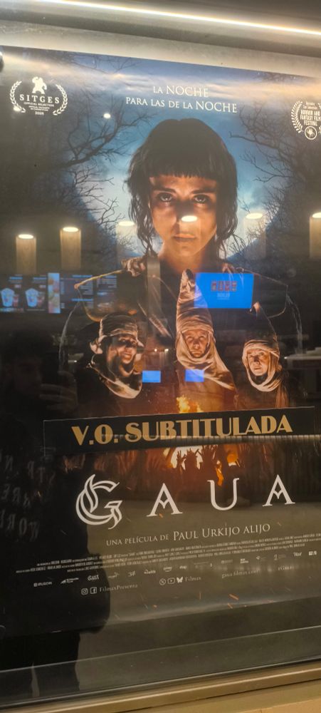 Poster de Gaua, película. 

Un mujer mirando al frente, debajo tres señoras, y debajo una hoguera con un montón de manos.