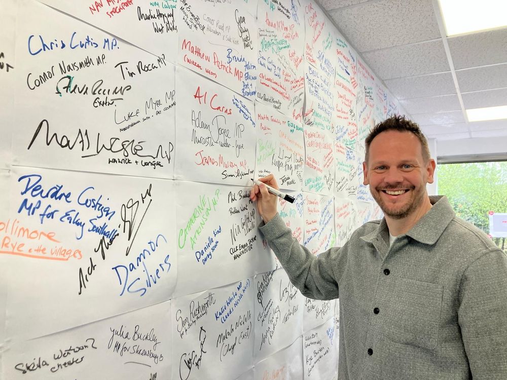Simon signing the volunteer wall