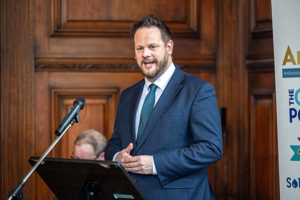 Simon speaking at the expo. Standing at a podium with a microphone