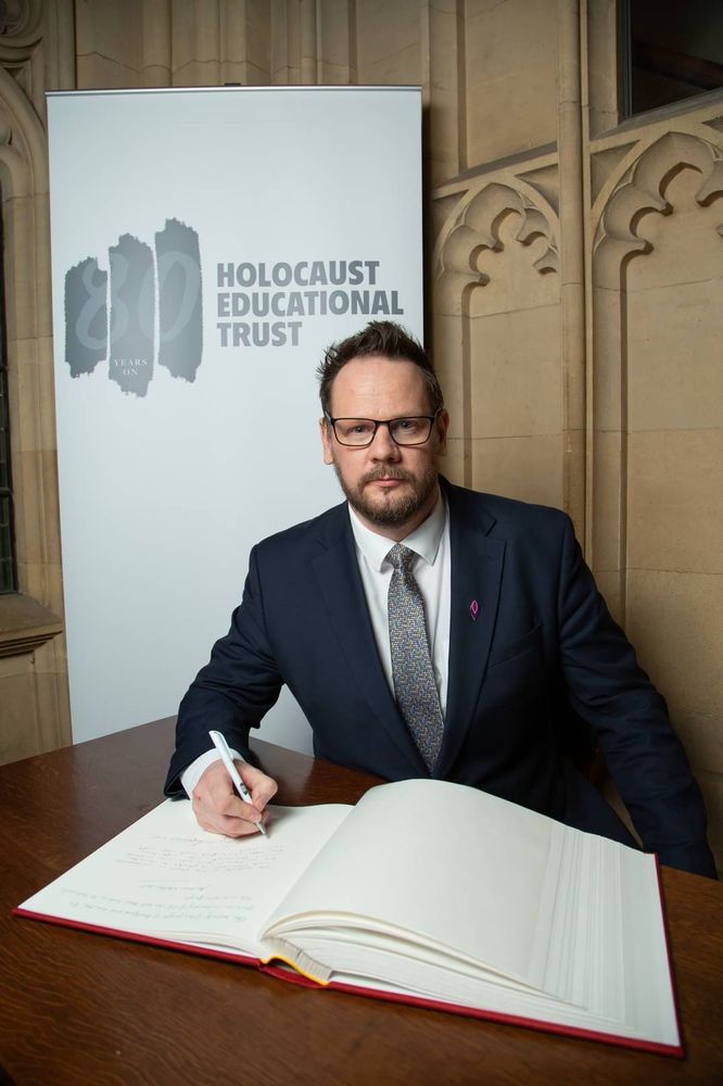 Simon signing the book of commitment.