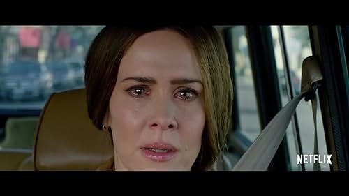 Actress Sarah Paulson in the movie Bird Box is driving a car. Her eyes have become cloudy after seeing an incomprehensibly horrifying creature.