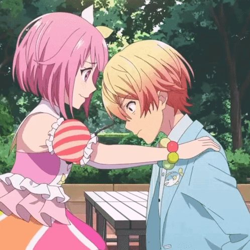 a boy and a girl are looking at each other and the girl is wearing a pink dress