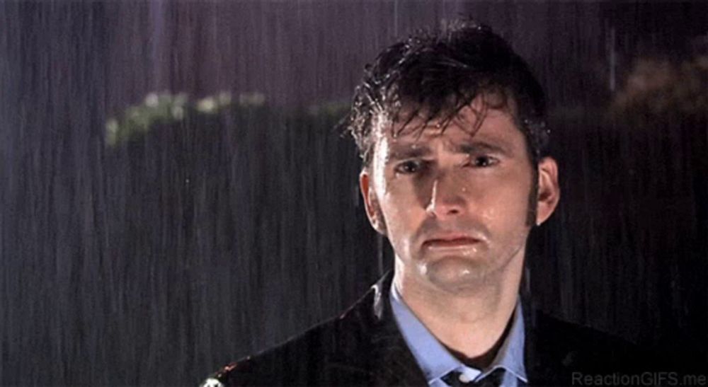 a man in a suit is crying in the rain