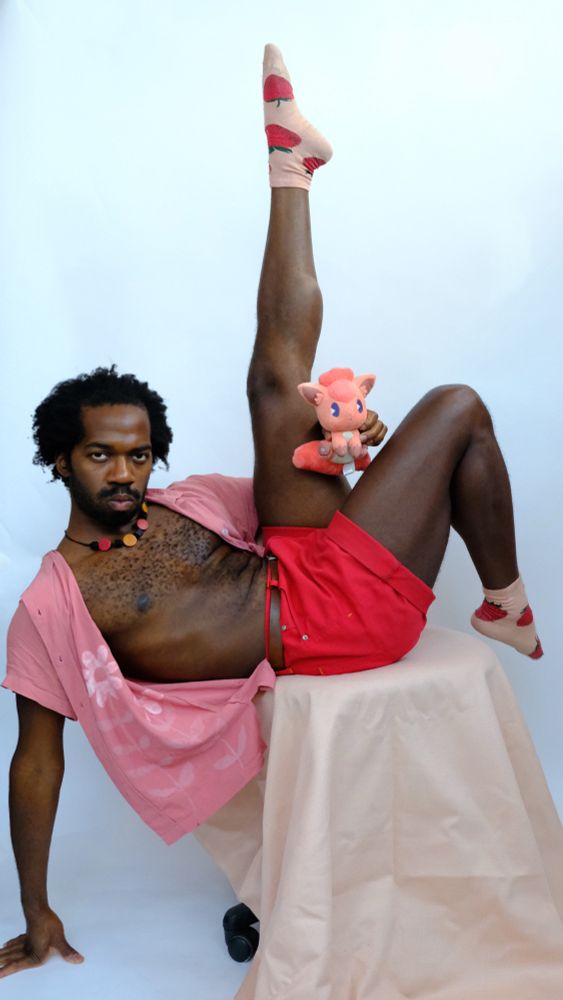 Odera posed in their studio wearing matching reds, pinks, and magentas. 