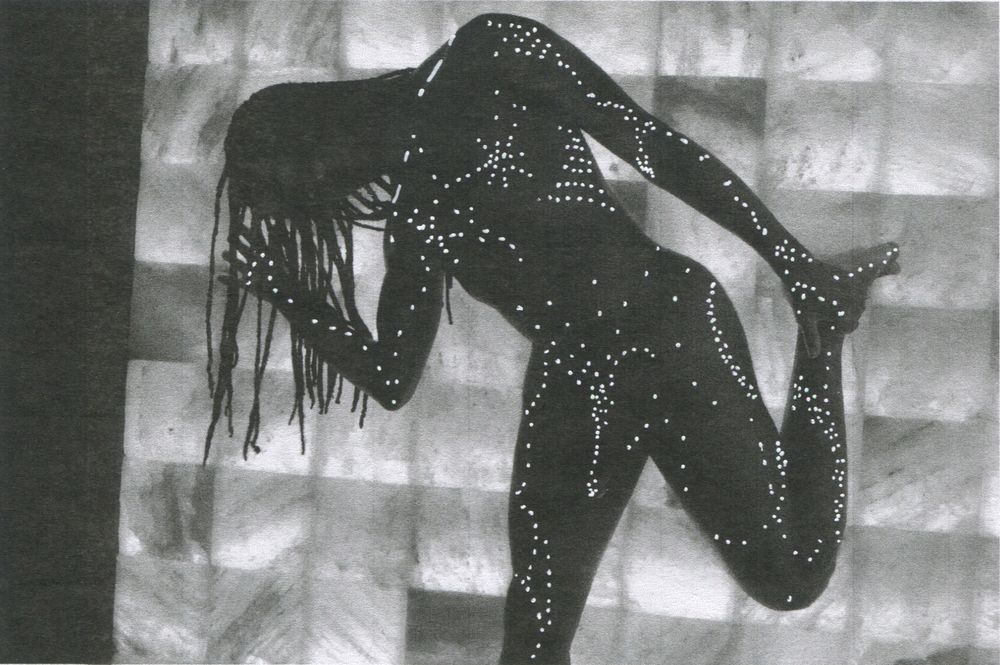 Odera’s silhouette in front of a sauna’s glowing salt wall. Ink pen dots and dances across their figure