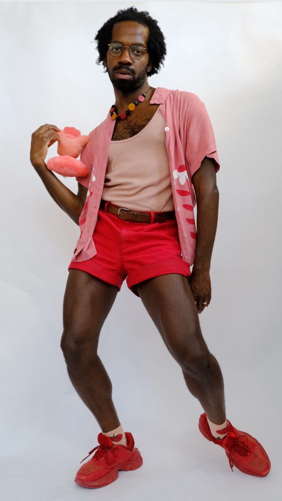 Odera posed in their studio wearing matching reds, pinks, and magentas. 